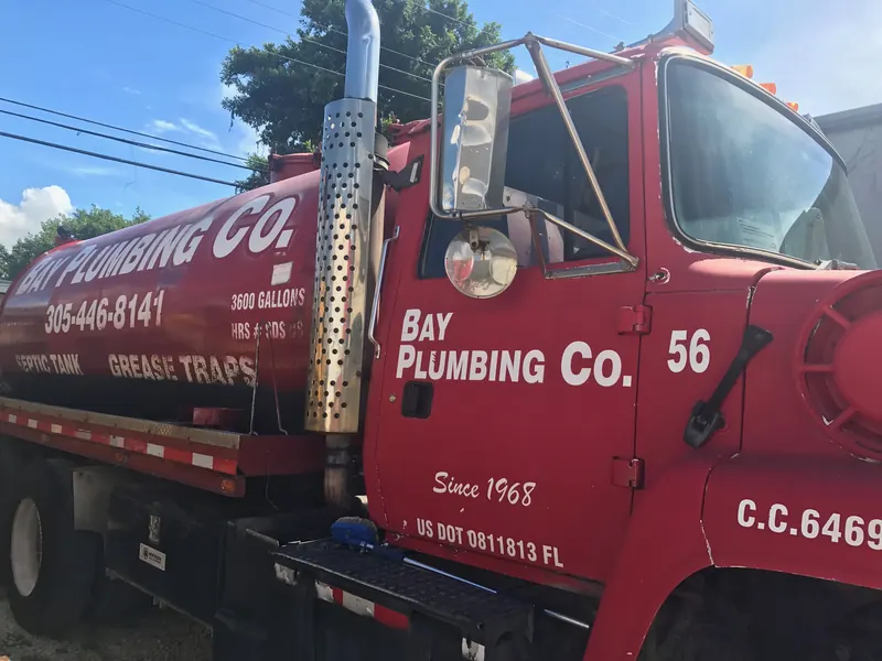 Bay Plumbing Co. truck 56, a red 3,600-gallon septic tank and grease trap truck lettered with 305-446-8141 and C.C. 6469.